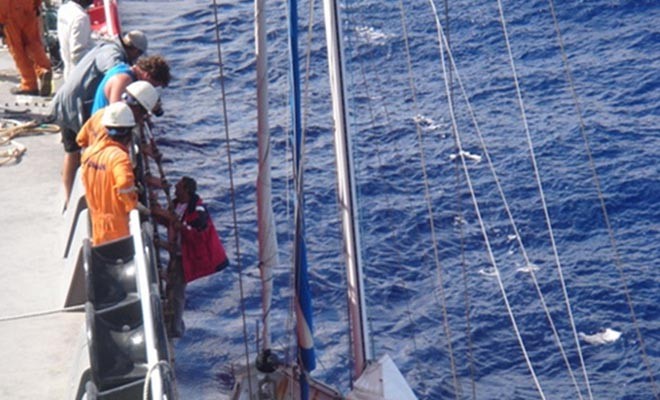 AMVER merchant seamen assist sailor to board their ship ©  SW